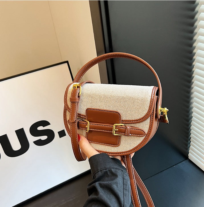 Natural and brown Sola Saddle Bag handheld closeup